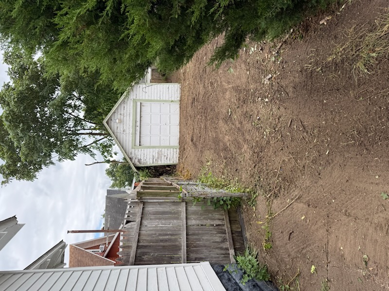 Cleared access area beside the house and garage
