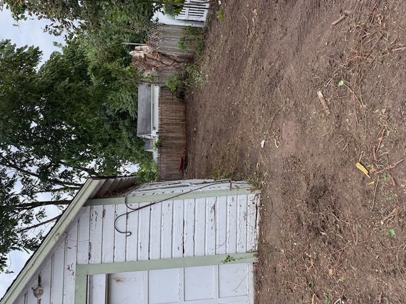 Cleared ground and fence line after property cleanup